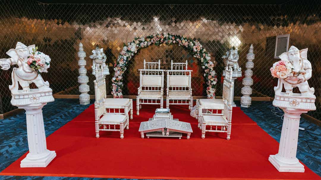 An Indian wedding Mandap setup at the Wolverhampton Rose Garden venue. The backdrop features intricate gold and white decorations.