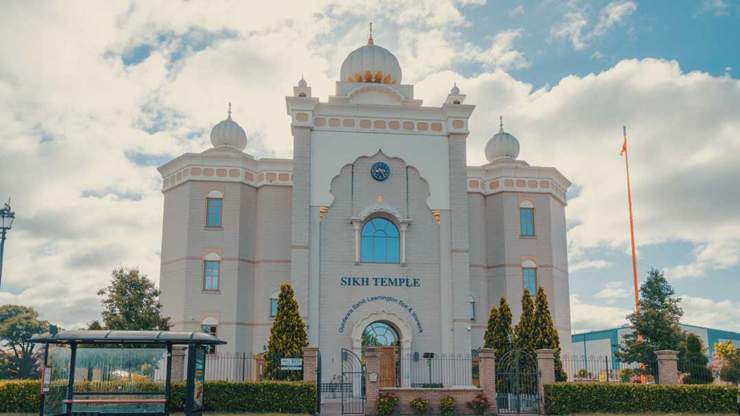 Beautifully crafted Lemangton Spa Sikh temple front in white and gold.