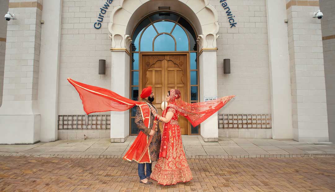 Sikh bride groom pose Leamington Gurdwara doors A Sikh bride and Sikh groom pose in front of the Leamington Gurdwara doors.