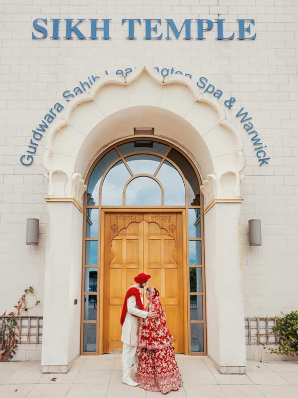 Sikh wedding Photography Leamington Spa A Sikh couple walks hand in hand in front of the Leamington Sikh Temple for the photoshoot.