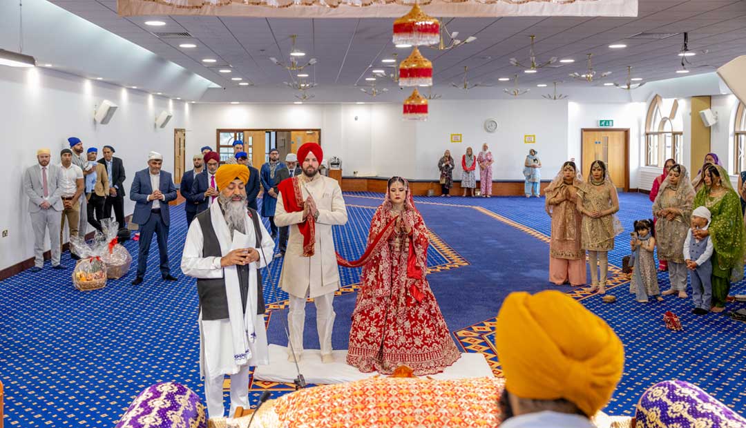 wedding Ardass Gurdwara Sahib Leamington During a Sikh wedding ceremony, a wedding congregation stands in front of the Guru Granth Sahib Ji, participating in the Ardass at Gurdwara Sahib Leamington Hall.