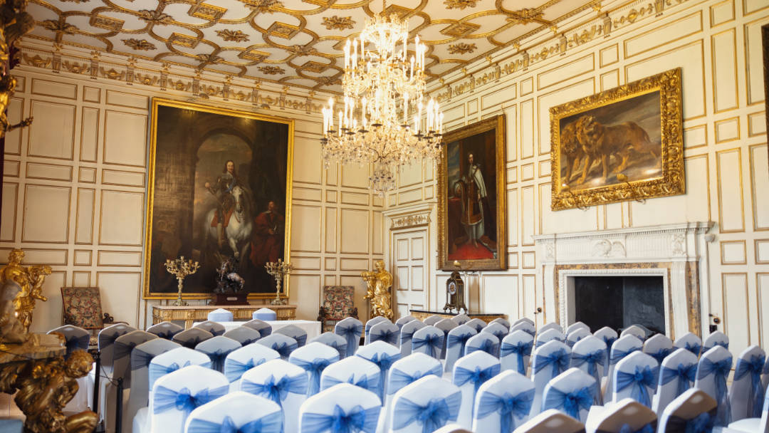 The State Dining Room photo at Warwick Castle features rows of decorated chairs.