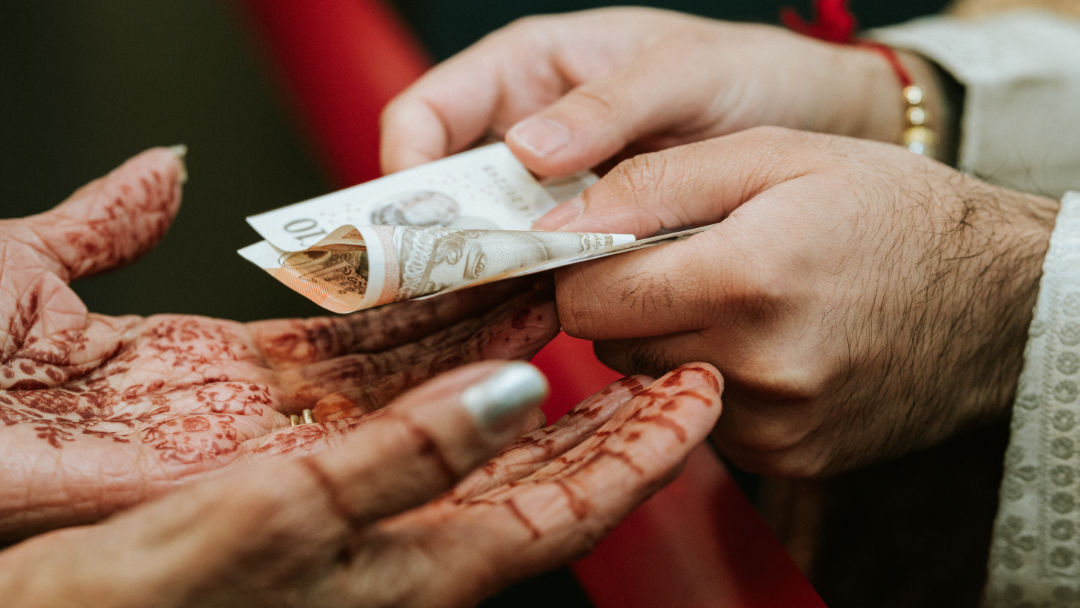 Sisters hold a groom's palla before the barrat in Coventry.