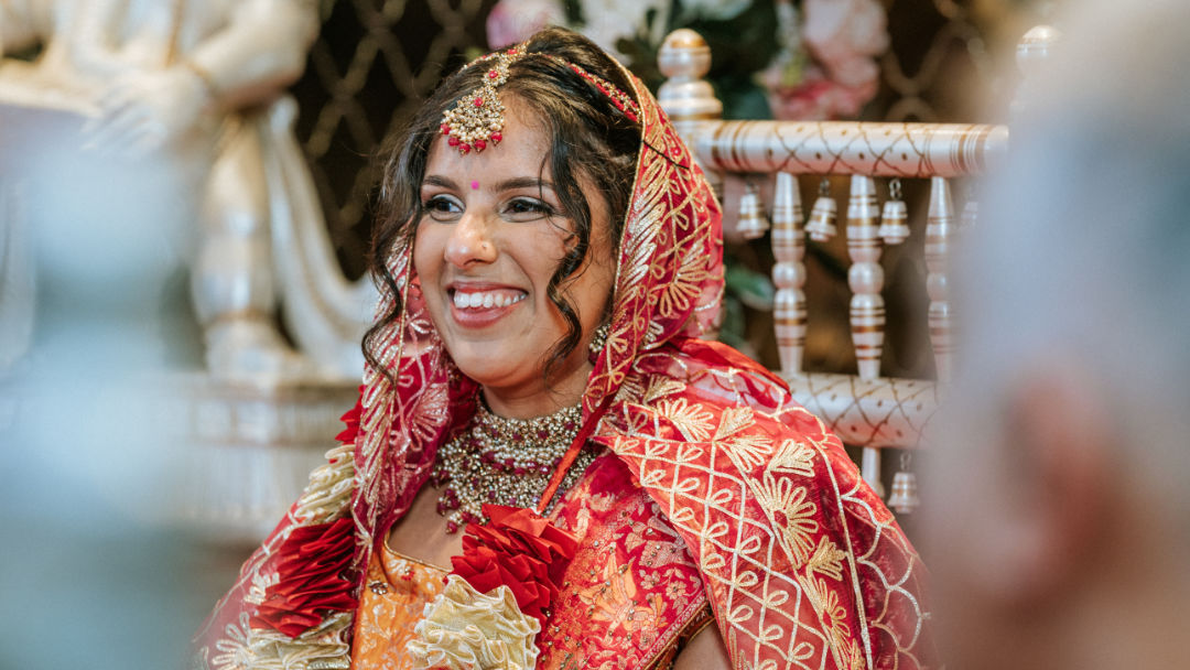 A sister places a Kalgi on the groom's Pagh before the barrat in Wolverhampton.