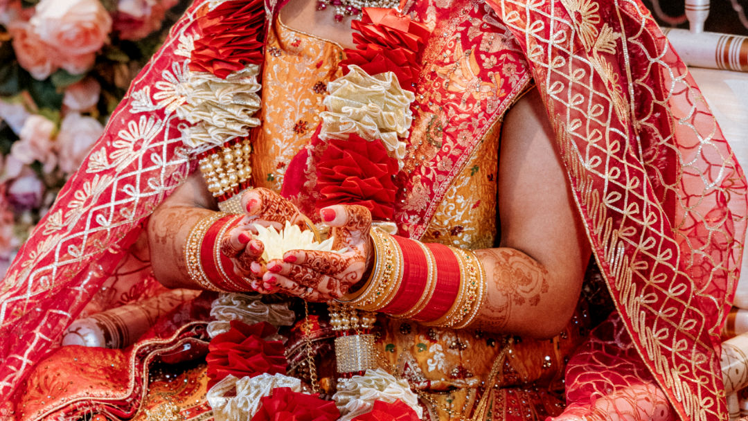 A sister places a Kalgi on the groom's Pagh before the barrat in Wolverhampton.
