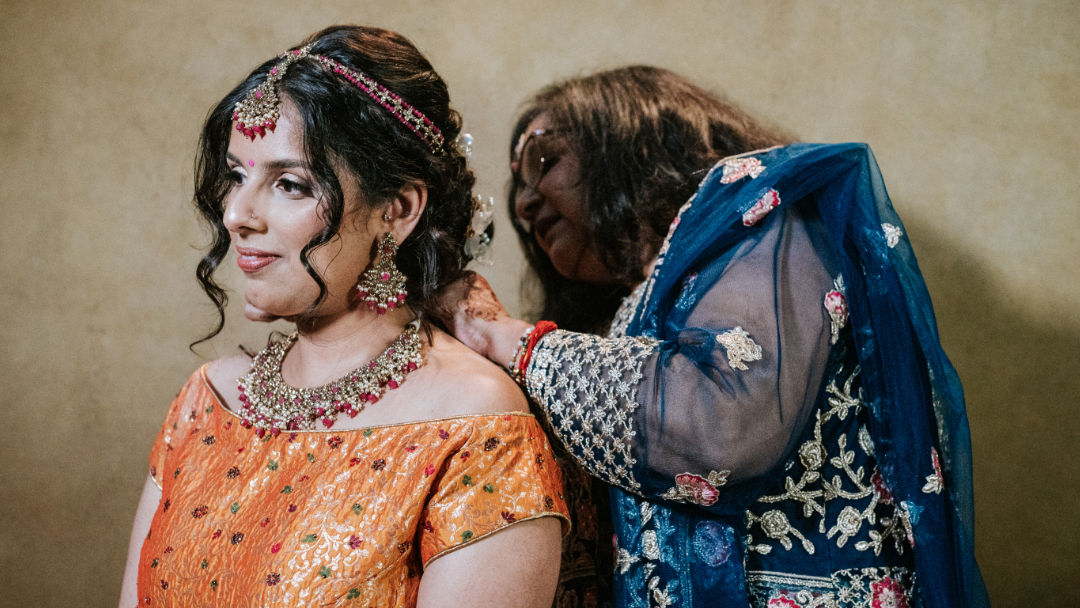 A person ties a cream colour Pagh or Turban on Sikh Groom's head at High Wycombe.